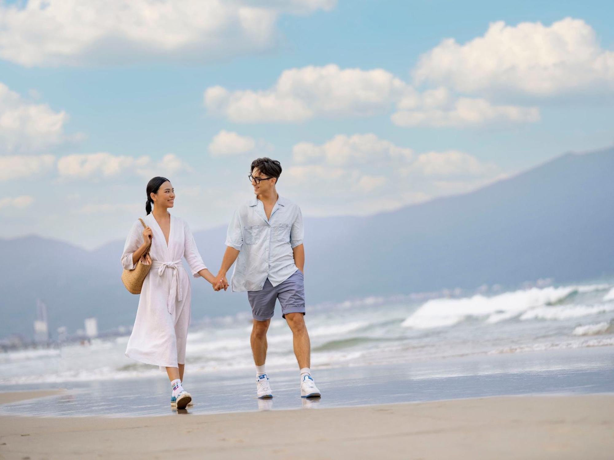 Dlg Hotel Danang Exterior photo A couple walking on the beach